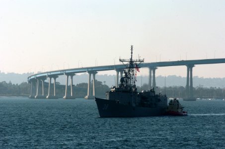 US Navy 051104-N-9866B-011 The guided missile frigate USS Curts (FFG 38) is guided into Naval Station San Diego with the help of a tugboat after passing underneath the Coronado Bridge