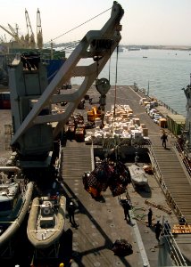 US Navy 051024-N-0716S-004 The crane aboard the dock landing ship USS Pearl Harbor (LSD 52) brings a load of relief supplies from the boat deck of the ship onto the pier in Karachi, Pakistan