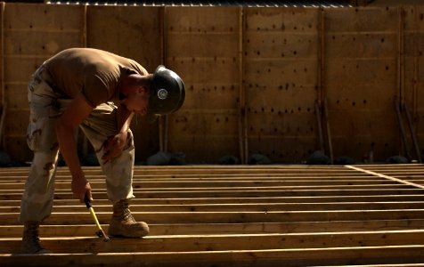 US Navy 051108-F-7234P-048 Inside a cordoned area, U.S. Navy Constructionman Jaime Hernandez, assigned to Naval Mobile Construction Battalion Three (NMCB-3), hammers nails into floorboards at Camp Lemonier