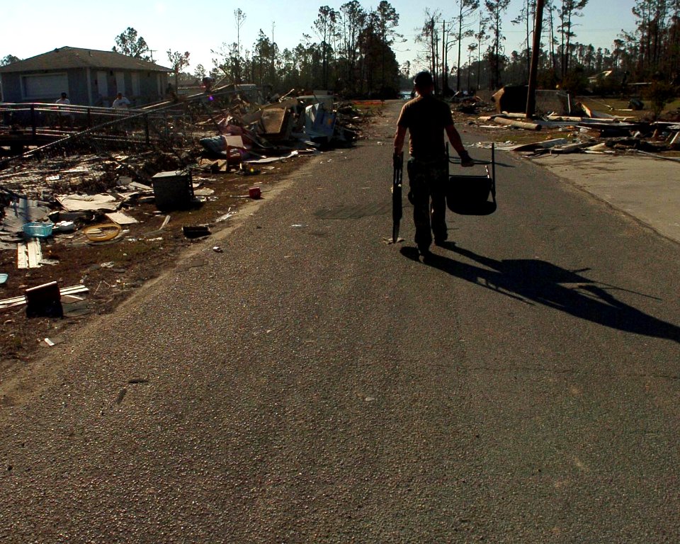 US Navy 051022-N-3729H-018 U.S. Navy Yeoman 3rd Class Weslet Ozment, assigned to the Nimitz-class aircraft carrier USS John C. Stennis (CVN 74), clears debris from the parking lot of Pass Christian High School
