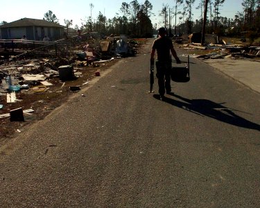 US Navy 051022-N-3729H-018 U.S. Navy Yeoman 3rd Class Weslet Ozment, assigned to the Nimitz-class aircraft carrier USS John C. Stennis (CVN 74), clears debris from the parking lot of Pass Christian High School