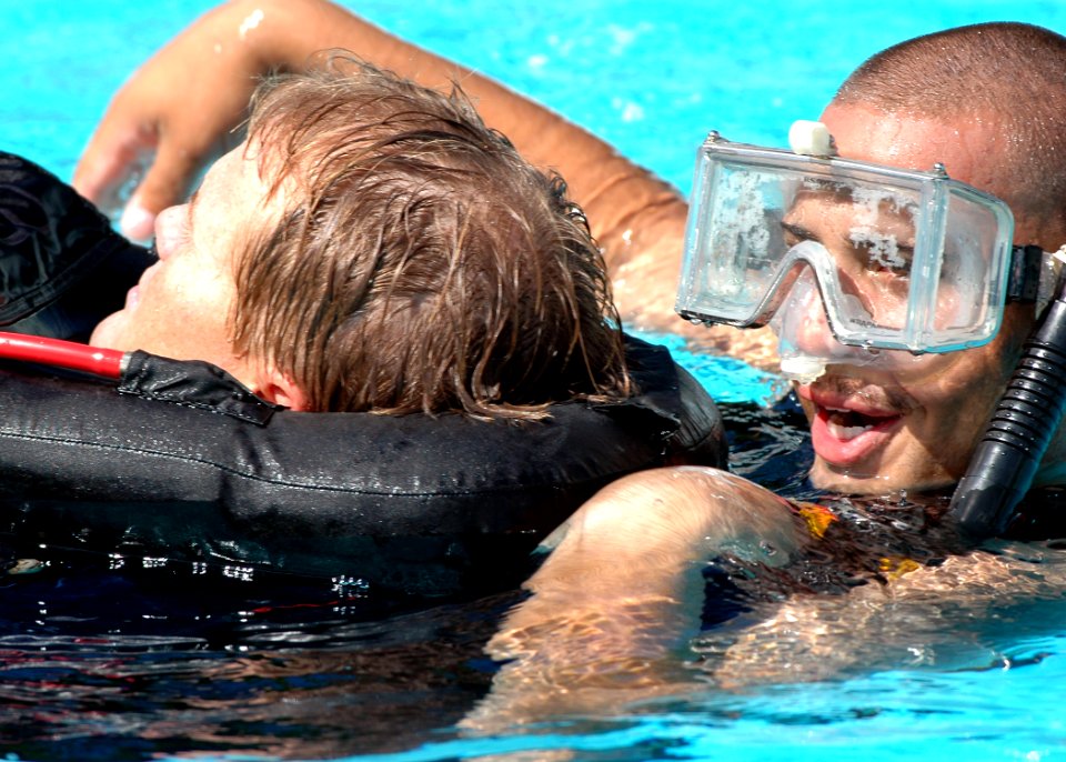 US Navy 051005-N-3019M-008 Boatswain's Mate 2nd Class Michael Santiago, assigned to the guided missile destroyer USS Paul Hamilton (DDG 60), aids a simulated victim during a search and rescue swimmer medical evacuation dr