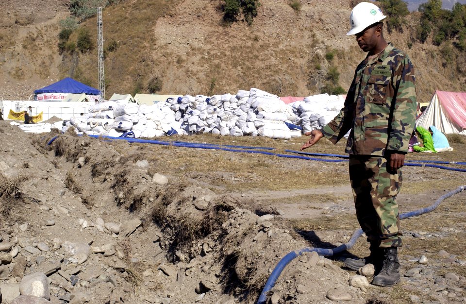 US Navy 051113-F-2729L-007 U.S. Navy Chief Equipment Operator Derrick Arrington, assigned to Naval Mobile Construction Battalion Seven Four (NMCB-74), points out a water pipeline trench that the Navy Seabees dug