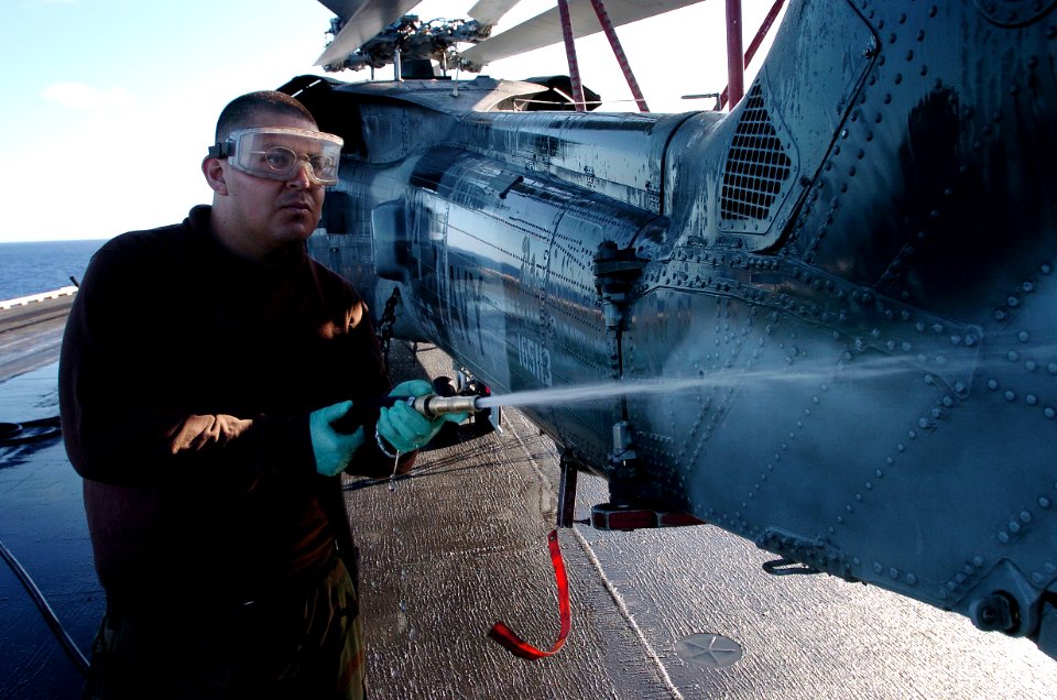 US Navy 051025-N-0413R-076 Airman Anthony Bejarano, assigned to the Indiansof Helicopter Anti-Submarine Squadron Six (HS-6), washes one of his squadron's HH-60H Seahawk helicopters