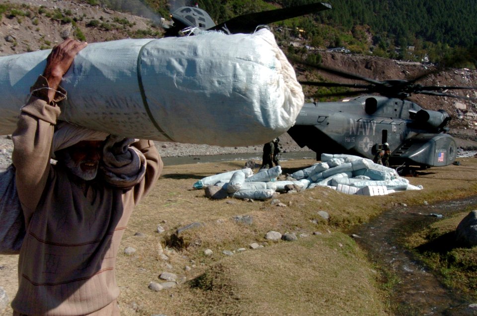 US Navy 051019-N-8796S-126 An elderly Pakistani man carries a tent away from a U.S. Navy MH-53 Sea Dragon helicopter