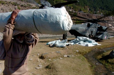 US Navy 051019-N-8796S-126 An elderly Pakistani man carries a tent away from a U.S. Navy MH-53 Sea Dragon helicopter