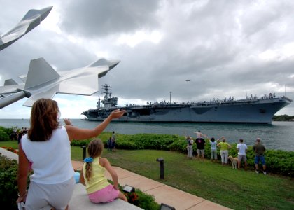 US Navy 051030-N-3019M-002 Family members wave to the nuclear-powered aircraft carrier USS Nimitz (CVN 68) as she passes the missing man memorial on board Hickam Air Force Base, and enters Pearl Harbor