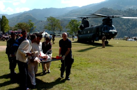 US Navy 051012-N-8796S-260 Members of the Pakistan military and civilians from multinational relief agencies carry an injured woman to a U.S. Army UH-60 Blackhawk helicopter for a medical evacuation in the remote Pakistani vill