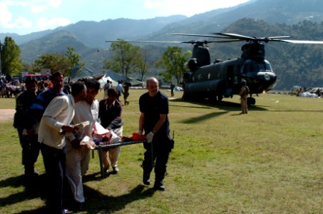 US Navy 051012-N-8796S-260 Members of the Pakistan military and civilians from multinational relief agencies carry an injured woman to a U.S. Army UH-60 Blackhawk helicopter for a medical evacuation in the remote Pakistani vill photo