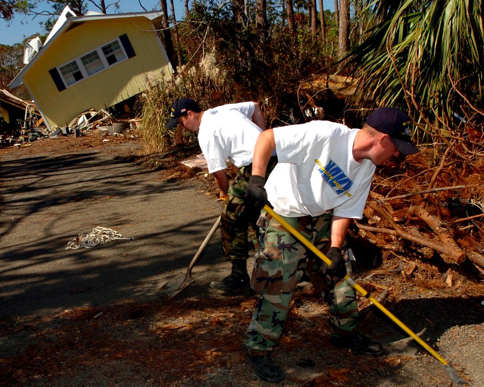 US Navy 051026-N-3729H-095 U.S. Navy Airman Salvatore Lombardi and Machinist Mate Fireman Andrew Westermire, both assigned to the Nimitz-class aircraft carrier USS John C. Stennis (CVN 74), help locals clear their driveway of d
