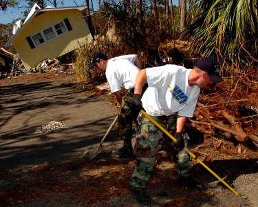 US Navy 051026-N-3729H-095 U.S. Navy Airman Salvatore Lombardi and Machinist Mate Fireman Andrew Westermire, both assigned to the Nimitz-class aircraft carrier USS John C. Stennis (CVN 74), help locals clear their driveway of d
