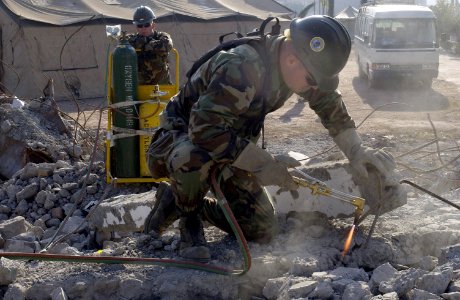 US Navy 051105-F-2729L-005 U.S. Navy Steel Worker Constructionman Casey Good, assigned to Naval Mobile Construction Battalion Seven Four (NMCB-74), cuts through rebar to aid in clearing debris