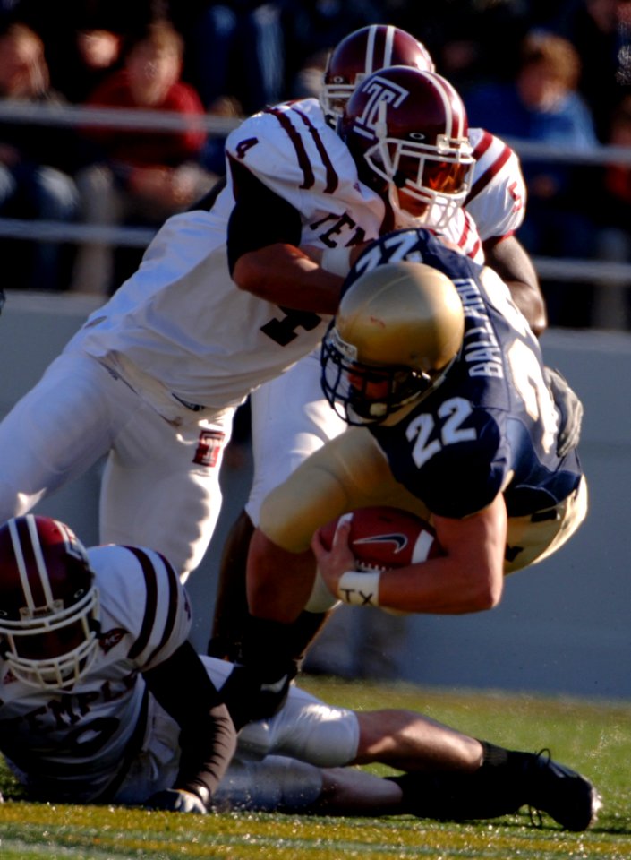 US Navy 051119-N-9693M-010 U.S. Naval Academy Midshipman full back Adam Ballard (22) is tackled by Temple Owls defender Justin Johnson (4) during the 1st quarter of play at Navy-Marine Corps Memorial Stadium
