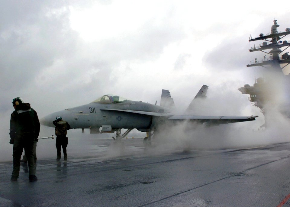 US Navy 051028-N-7359L-001 An F-A-18C Hornet, assigned to the Bulls of Strike Fighter Squadron Three Seven (VFA-37), is directed onto a steam-powered catapult