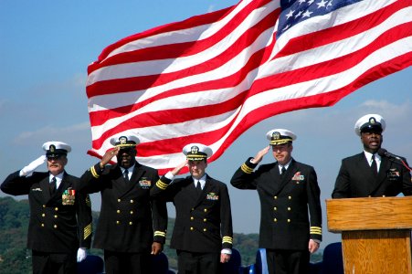 US Navy 051013-N-6106R-010 Chief Aviation Boatswain's Mate Michael Berry, far left, and members of the official party salute as the national anthem is sung during Berry's retirement ceremony photo