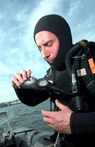 US Navy 051119-N-9851B-004 U.S. Navy Chief Sonar Technician Isaac Callicrate, assigned to Explosive Ordnance Disposal Mobile Unit Five (EODMU-5), Detachment Japan, checks his regulator before diving
