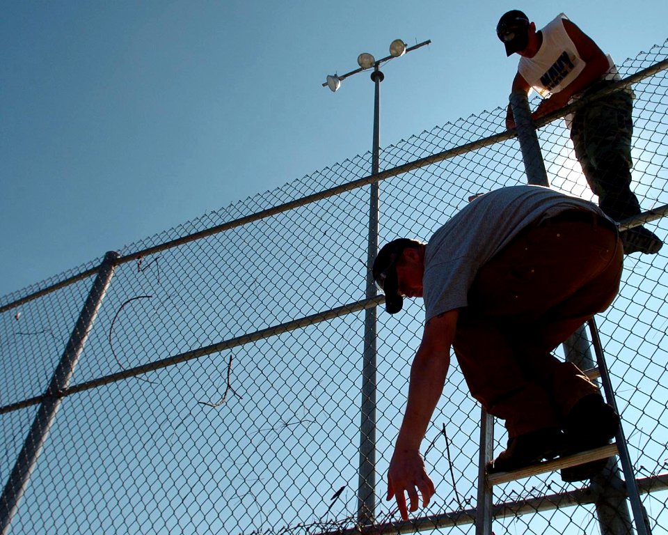 US Navy 051022-N-3729H-035 U.S. Navy Sailors assigned to the Nimitz-class aircraft carrier USS John C. Stennis (CVN 74), reassemble a section of chain linked fence damaged by Hurricane Katrina