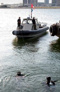 US Navy 051119-N-9851B-013 Members of Explosive Ordnance Disposal Mobile Unit Five (EODMU-5), Detachment Japan, tend to divers from their position on a Rigid Hull Inflatable Boat (RHIB)