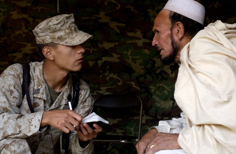 US Navy 051120-F-2729L-004 U.S. Navy Hospitalman Garret Castro, left, gathers information from a patient at the field hospital in Shinkiari, Pakistan