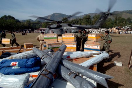 US Navy 051014-N-8796S-139 Pakistani soldiers carry medical supplies off of a U.S. Navy MH-53E Sea Stallion helicopter in Muzafarabad, Pakistan photo