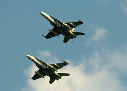 US Navy 051109-N-3488C-078 Two F-A-18C Hornets, assigned to the Dambusters of Strike Fighter Squadron One Nine Five (VFA-195), fly alongside the conventionally powered aircraft carrier USS Kitty Hawk (CV 63)