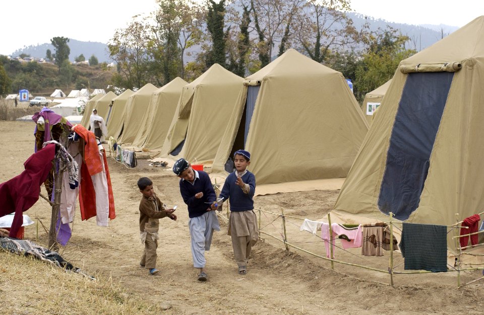US Navy 051121-F-2729L-001 Pakistani children play with a toy helicopter at Jabba Farm Tent Village in Shinkiari, Pakistan