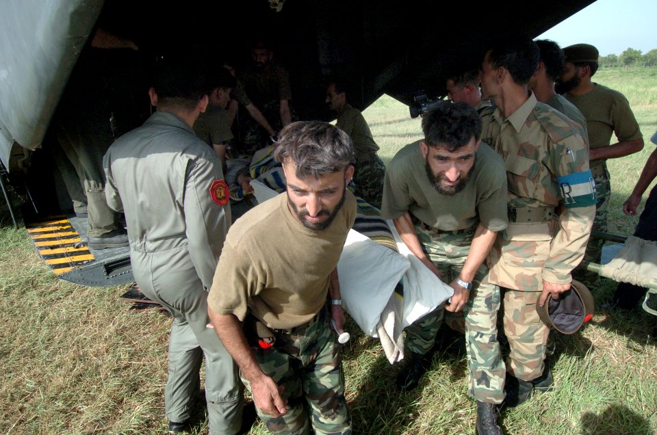 US Navy 051014-N-8796S-189 Pakistani soldiers carry an injured woman off of a U.S. Navy MH-53E Sea Stallion helicopter in Chaklala, Pakistan