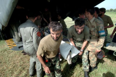 US Navy 051014-N-8796S-189 Pakistani soldiers carry an injured woman off of a U.S. Navy MH-53E Sea Stallion helicopter in Chaklala, Pakistan photo