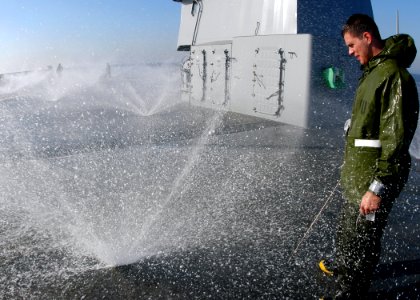 US Navy 051122-N-7526R-062 Damage Controlman 3rd Class Christopher Hejl verifies the effectiveness of a sprinkler on the main deck of the amphibious command ship USS Blue Ridge (LCC 19) during a fresh water countermeasure wash photo