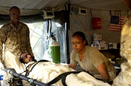 US Navy 051120-F-2729L-003 U.S. Navy Hospitalman Lashen Washington, left, and Hospital Corpsman 3rd Class Althea Caraballo lift a patient onto a litter at the field hospital in Shinkiari, Pakistan
