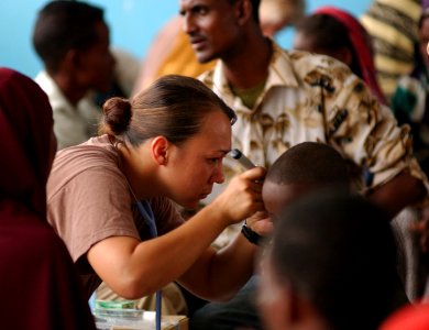 US Navy 051109-F-8425S-256 U.S. Navy Hospital Corpsman Miami Gollyhorn looks into the ears of a local child with an otoscope during a medical examination in Gode, Ethiopia photo