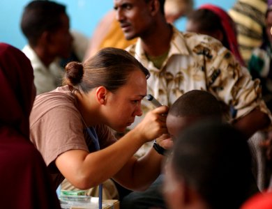 US Navy 051109-F-8425S-256 U.S. Navy Hospital Corpsman Miami Gollyhorn looks into the ears of a local child with an otoscope during a medical examination in Gode, Ethiopia