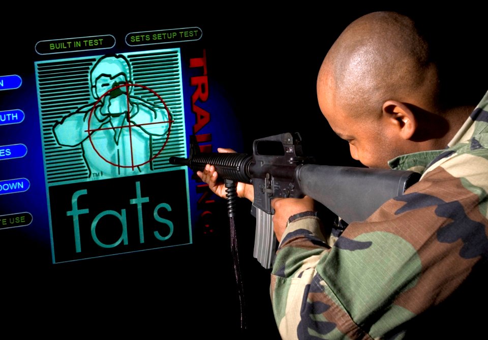 US Navy 051110-N-3390M-001 Master-at-Arms 2nd Class Marshall Davis, assigned to Security on board Naval Station Everett, takes aim on the station's FireArms Training Simulator (FATS)