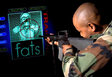 US Navy 051110-N-3390M-001 Master-at-Arms 2nd Class Marshall Davis, assigned to Security on board Naval Station Everett, takes aim on the station's FireArms Training Simulator (FATS)