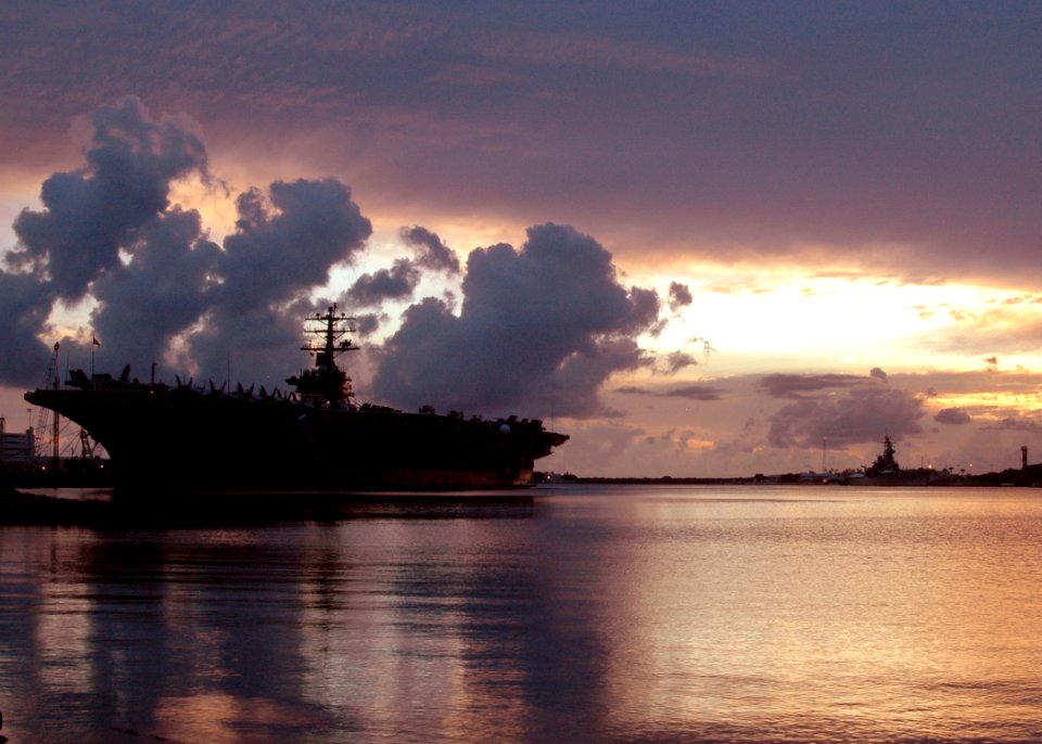 US Navy 051030-N-3019M-006 he nuclear-powered aircraft carrier USS Nimitz (CVN 68) sits moored in Pearl Harbor, Hawaii as the sunsets, after arriving for a brief port visit