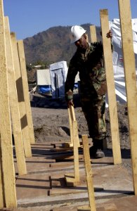 US Navy 051113-F-2729L-013 U.S. Navy Chief Equipment Operator Derrick Arrington, assigned to Naval Mobile Construction Battalion Seven Four (NMCB-74), points out field latrines that his team constructed
