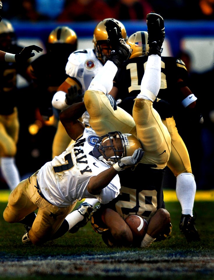 US Navy 051203-N-9769P-549 Navy slot back Reggie Campbell (7) of Sanford, Fla., tackles Army Running Back Scott Wesley (82) during a punt return during the 106th Army vs. Navy Football game held for the third consecutive year a