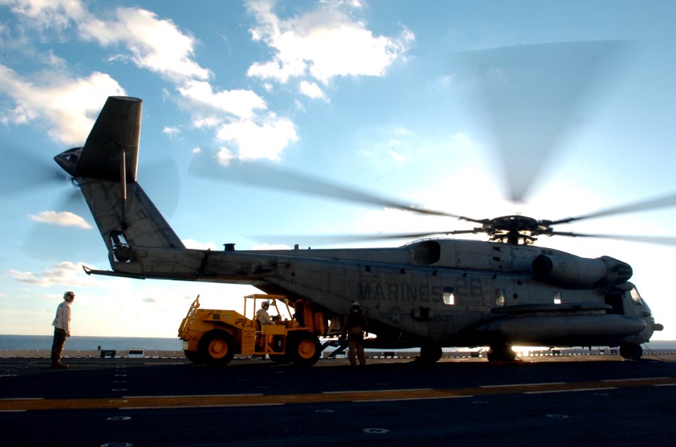US Navy 051203-N-9866B-057 Combat Cargo Marines assigned to the 11th Marine Expeditionary Unit load equipment on a CH-53 Super Stallion helicopter on the flight deck of the amphibious assault ship USS Peleliu (LHA 5)