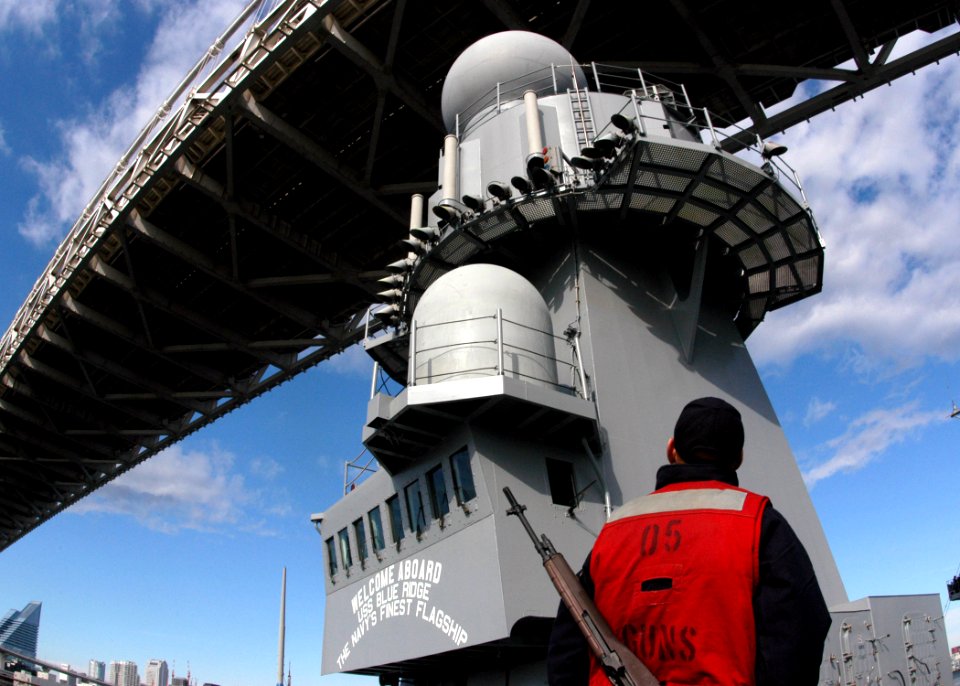 US Navy 051119-N-7526R-111 Gunner's Mate Seaman Donald Snyder, watches as amphibious command ship USS Blue Ridge (LCC 19) narrowly passes under Tokyo's Rainbow Bridge