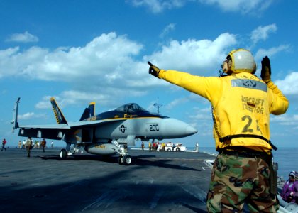 US Navy 051025-N-3488C-003 Aviation Boatswain Mate 2nd Class Paul Young directs an F-A-18E Super Hornet