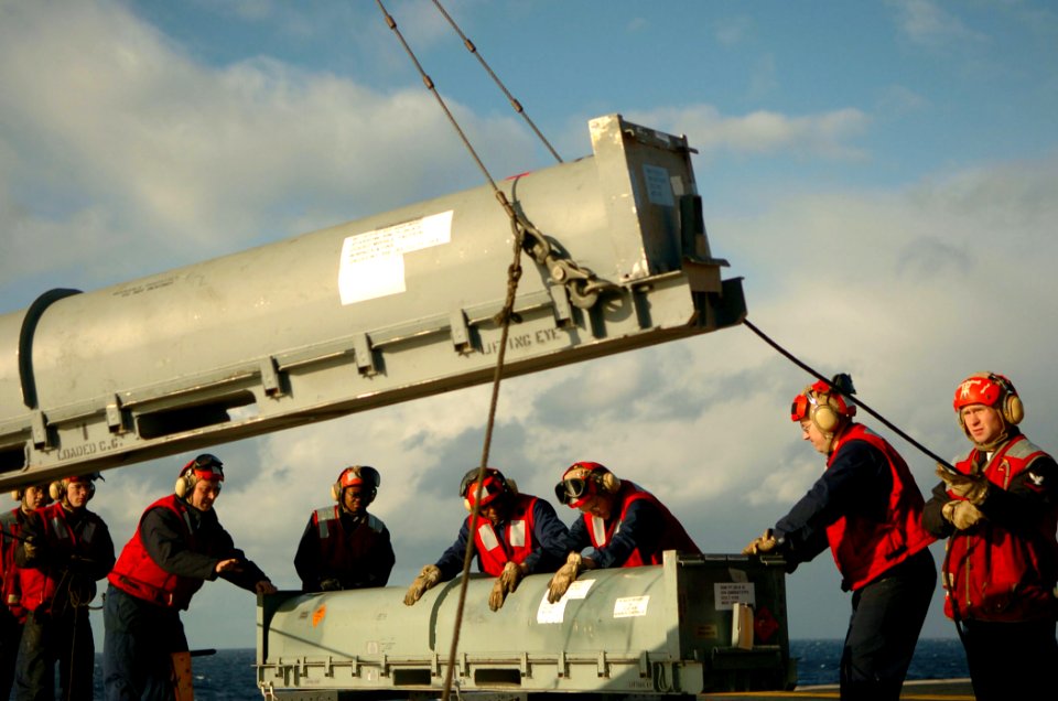US Navy 051206-N-3488C-021 Fire Controlmen stabilize a RIM-7 NATO Sea Sparrow missile container as it is lifted to the flight deck aboard the conventionally powered aircraft carrier USS Kitty Hawk (CV 63)