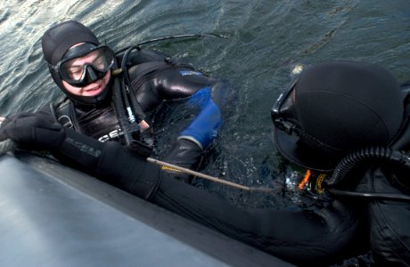 US Navy 051119-N-9851B-009 U.S. Navy Aviation Ordnanceman 1st Class Brandon Smith, left, and Chief Sonar Technician Isaac Callicrate return to their boat after diving into Tokyo Bay