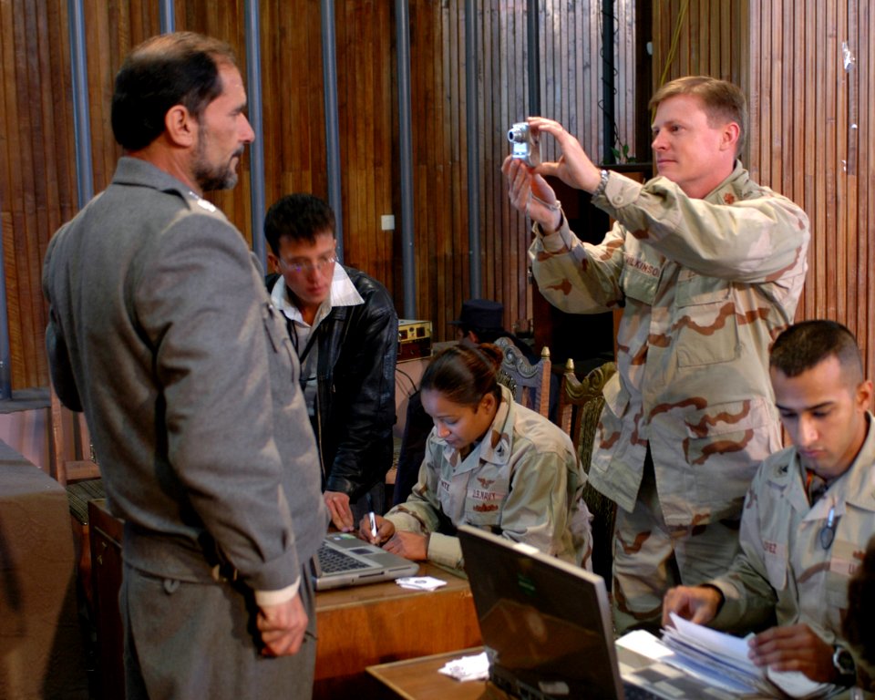 US Navy 051124-F-4306H-001 From right, U.S. Navy Petty Officer 2nd Class Luis Joseph Lopez, Lt. Cmdr. Joe Wilkinson and Petty Officer 1st Class Salisha Labonte, assist an Afghan National Police (ANP) General as he registers photo