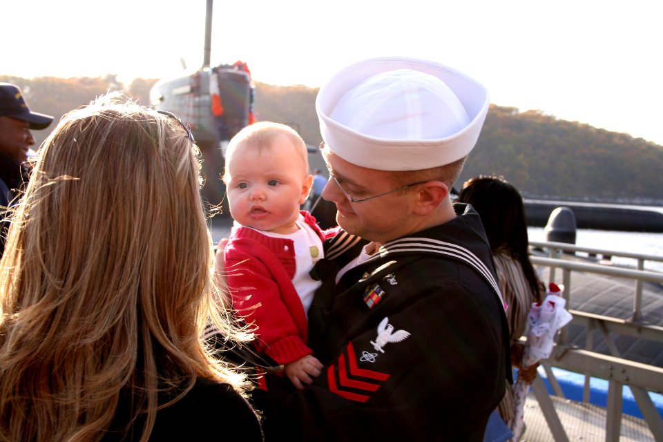 US Navy 051103-N-0653J-007 A Sailor assigned to the Los Angeles-class fast attack submarine USS Memphis (SSN 691), holds his daughter