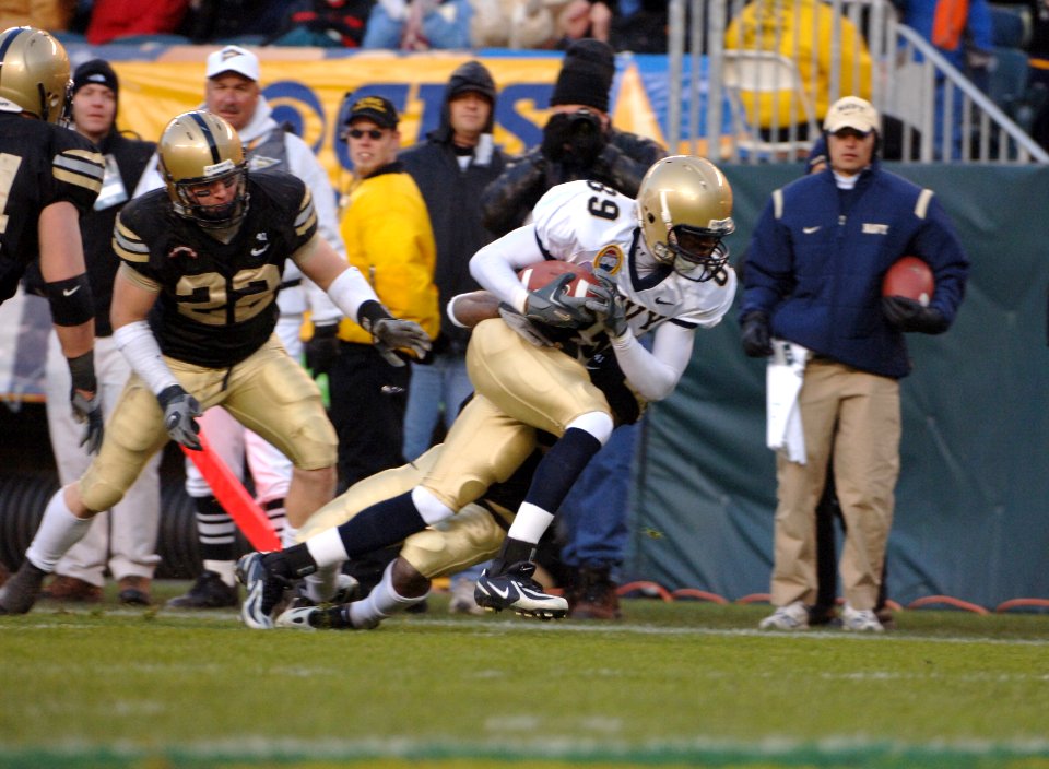 US Navy 051203-N-9693M-190 Navy wide receiver Tyree Barnes from Hampton, Va., breaks tackles while running for first down yardage, during the 106th Army vs. Navy Football game