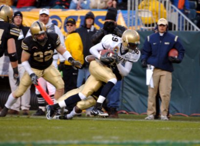 US Navy 051203-N-9693M-190 Navy wide receiver Tyree Barnes from Hampton, Va., breaks tackles while running for first down yardage, during the 106th Army vs. Navy Football game