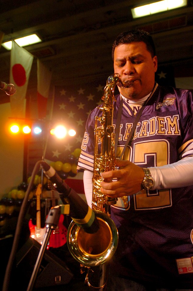US Navy 051221-N-9866B-305 Musician Chief Petty Officer Frank Dominguez of the Electric Brigade plays the Saxophone during a pep rally