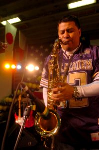 US Navy 051221-N-9866B-305 Musician Chief Petty Officer Frank Dominguez of the Electric Brigade plays the Saxophone during a pep rally