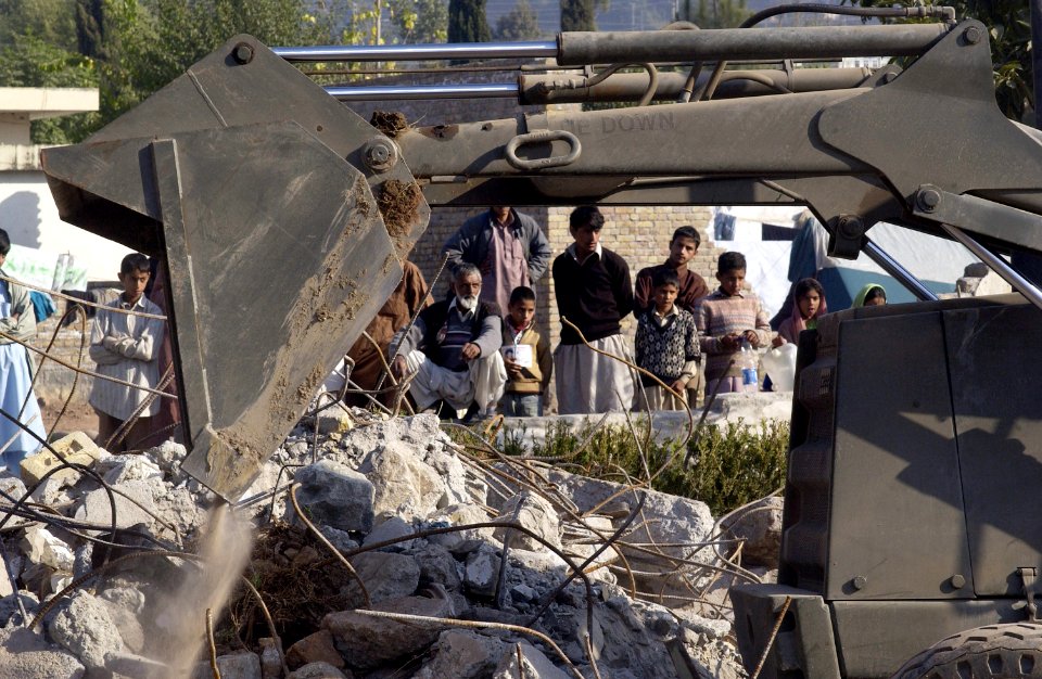 US Navy 051105-F-2729L-006 Seabees assigned to Naval Mobile Construction Battalion Seven Four (NMCB-74) clear debris to allow for expansion of Dewan Tent City
