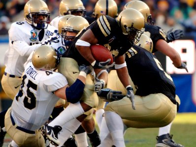 US Navy 051203-N-9693M-505 Army fullback Mike Viti (33) is tackled by a trio of Navy defenders during the 106th Army vs. Navy Football game, held for the third consecutive year at Lincoln Financial Field